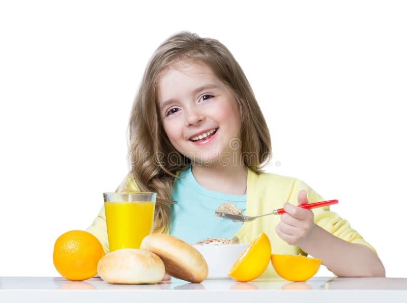 Child girl eating at table isolated on white.